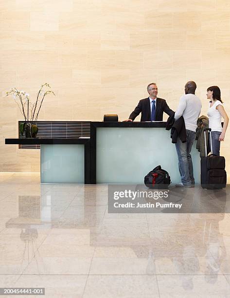 couple checking in to hotel - reception hotel photos et images de collection