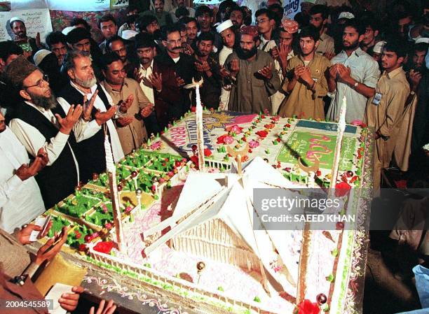 Leaders and the party workers of the Pakistan's largest religious party Jamaat-i-Islami offer prayers after cutting a 500-pound cake to mark the...