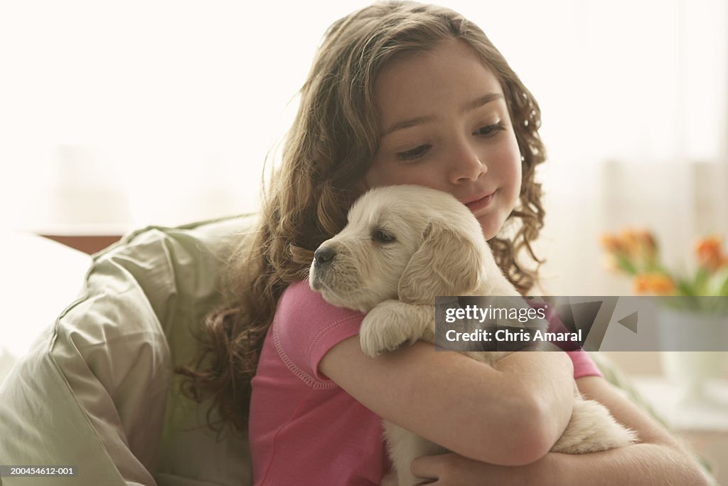 Young girl (8-10) holding dog