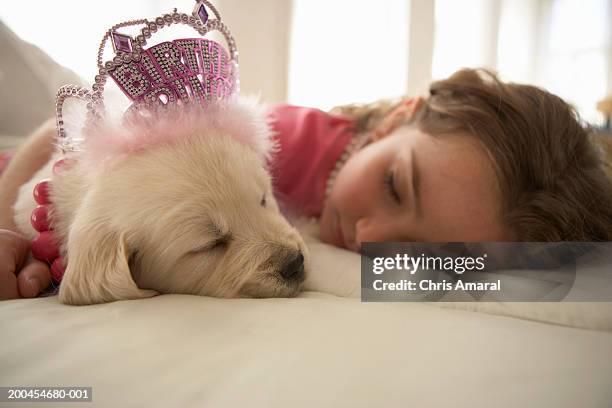 Young girl (8-10) sleeping on bed with dog