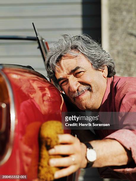 mature man polishing side of classic sports car, close-up - loving your car stock pictures, royalty-free photos & images
