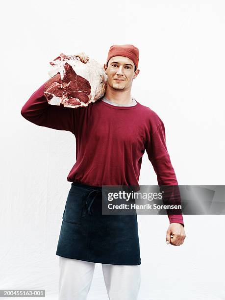 male butcher carrying meat on shoulder, portrait - butcher portrait stock-fotos und bilder