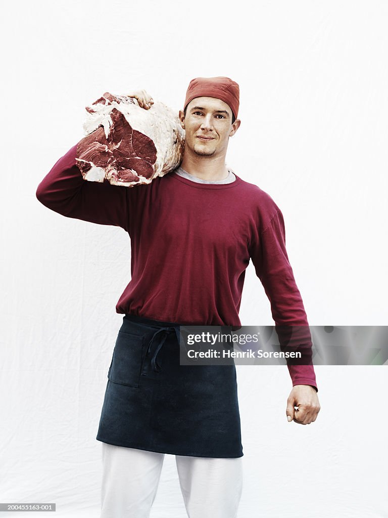 Male butcher carrying meat on shoulder, portrait