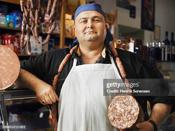 male butcher holding traditional italian sausage meats, portrait - butcher portrait stock pictures, royalty-free photos & images