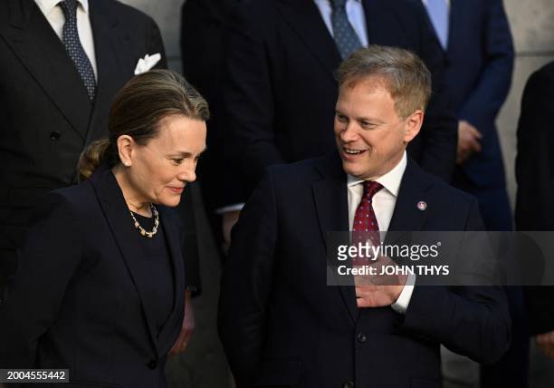 Permanent Representative to NATO Julianne Smith speaks with Britain's Defense Minister Grant Shapps as they prepare for a group photo after the...