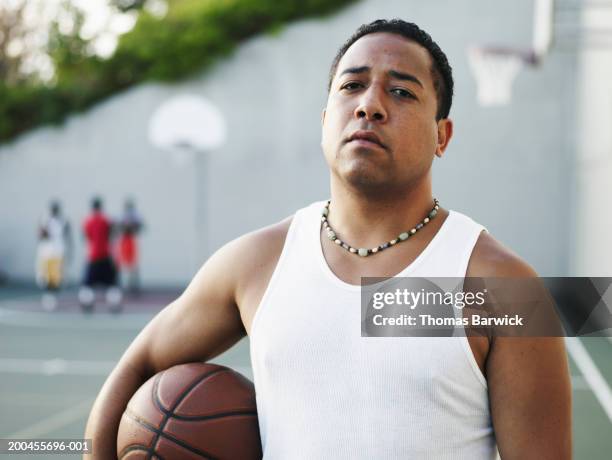 young man holding basketball on outdoor basketball court, portrait - bead necklace stock pictures, royalty-free photos & images