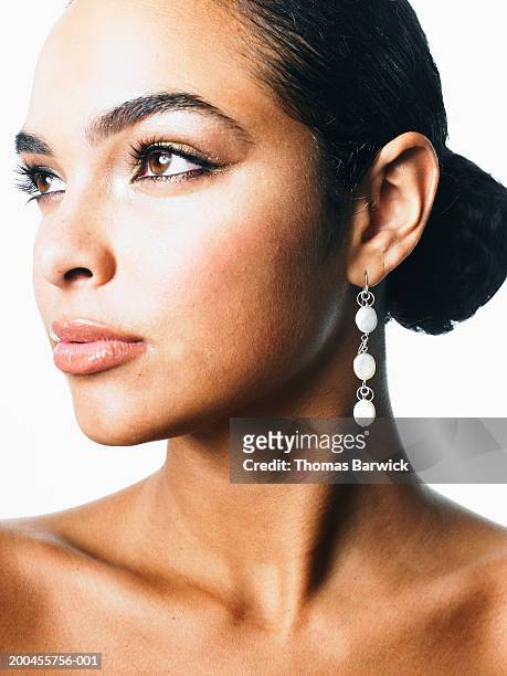 young woman wearing freshwater pearl earrings, looking away - perlenohrringe stock-fotos und bilder