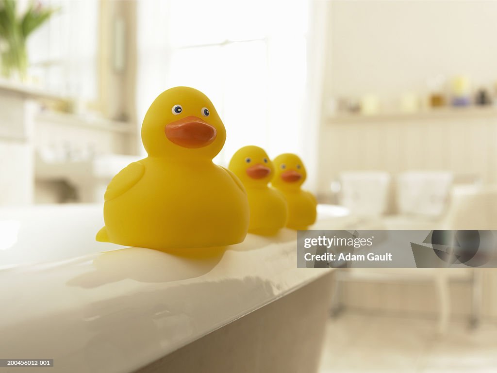 Rubber ducks in a row on edge of bath