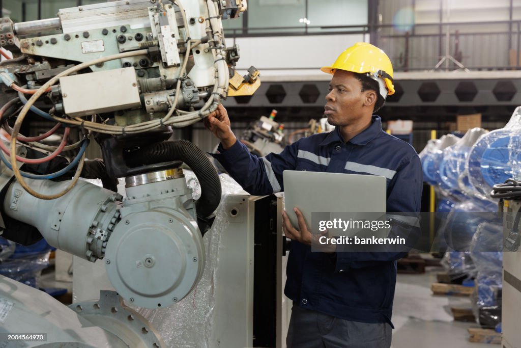 Ingenieur prüft Roboterarm in der Fabrik