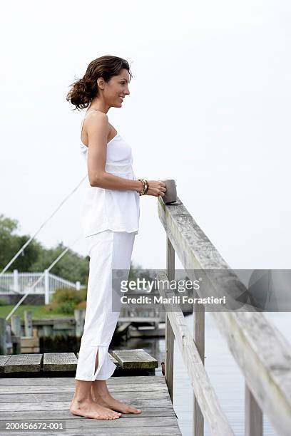 young woman smiling on dock, side view - the hamptons stock pictures, royalty-free photos & images