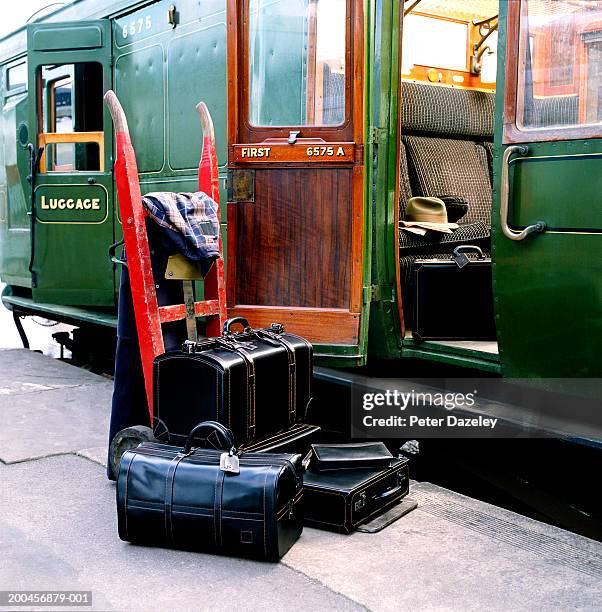 luggage on platform beside train, carriage door open - treincoupé stockfoto's en -beelden