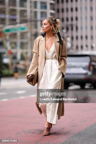 Guest wears a beige trench long coat , a low neck / v-neck, long cotton dress in white , a brown leather bag with golden handle, brown leather shoes,...