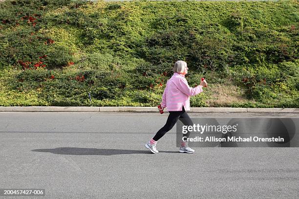 senior woman exercise walking on road, side view - old woman side view foto e immagini stock