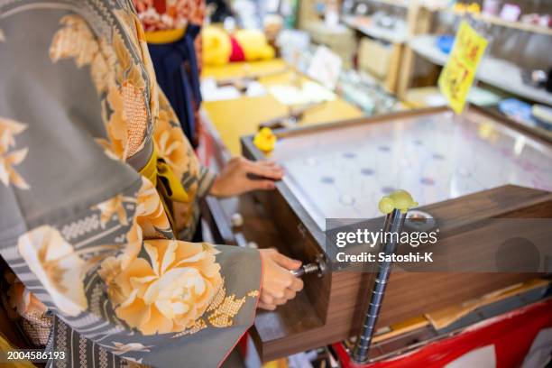 female friends in kimono / hakama playing ‘smart ball’ - old japanese style pinball - pinball stock pictures, royalty-free photos & images