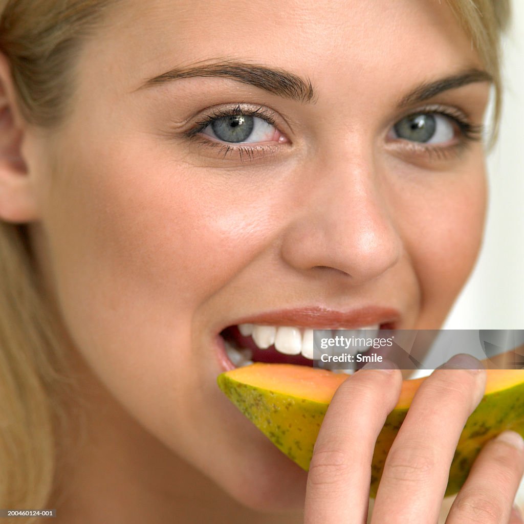 Woman eating melon, portrait