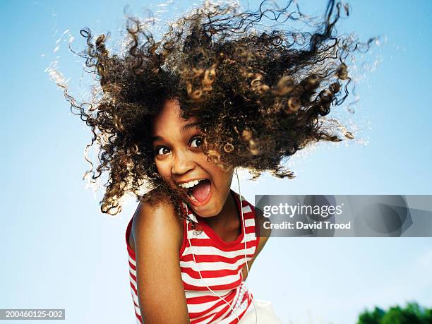 girl (10-12) wearing earphones, outdoors, smiling, portrait - girl 11 12 laughing close up foto e immagini stock