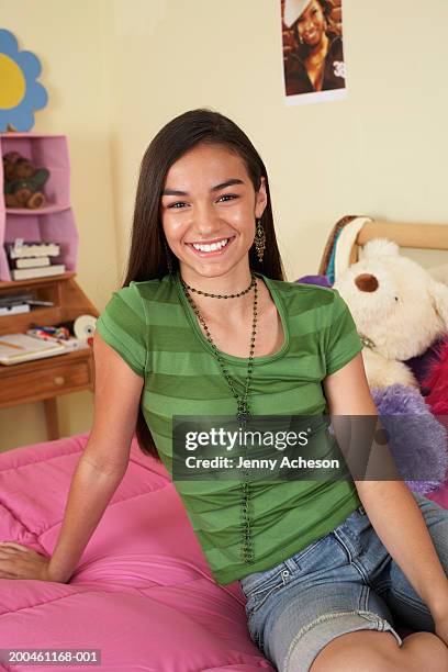 girl (13-15) relaxing on bed, smiling, portrait - ot ストックフォトと画像