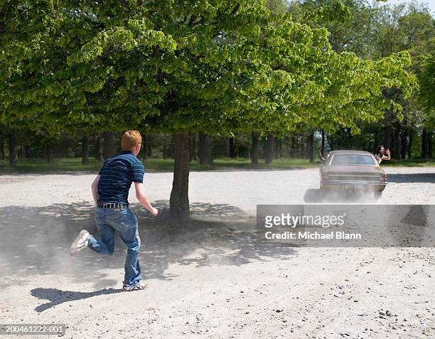 young man chasing car - chasing stock-fotos und bilder