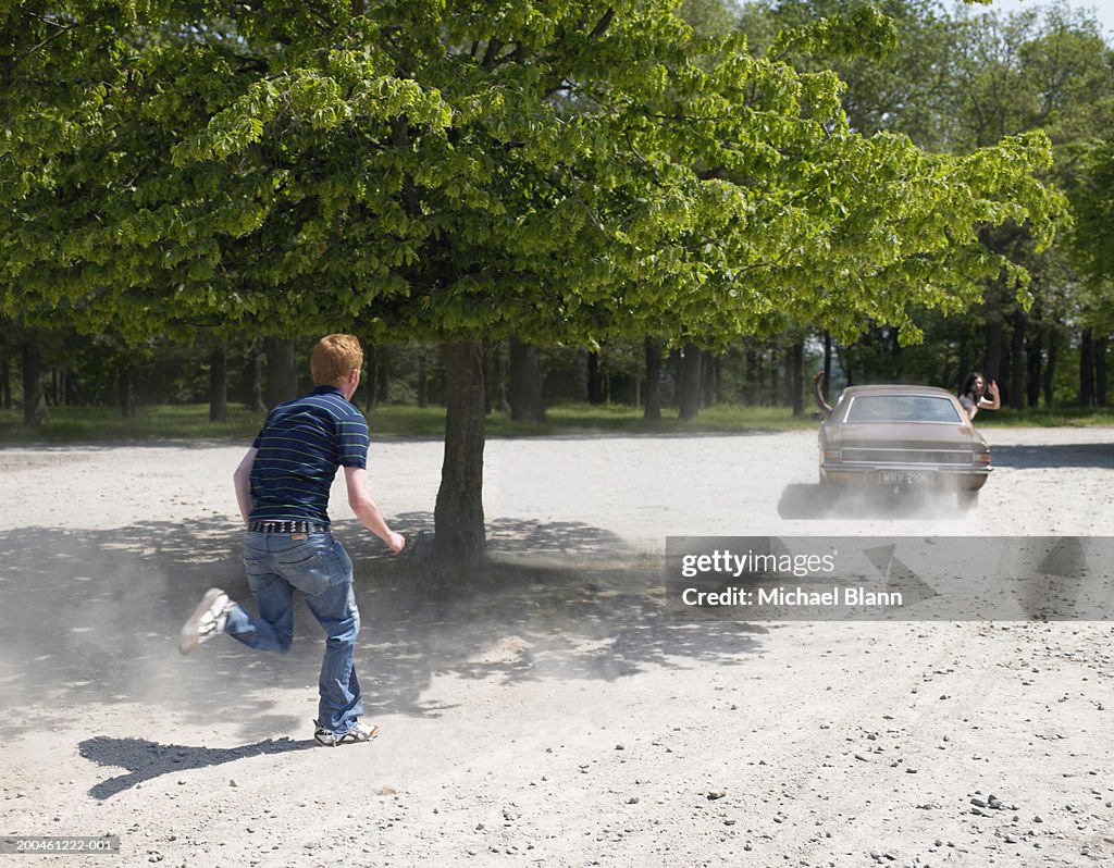 Young man chasing car