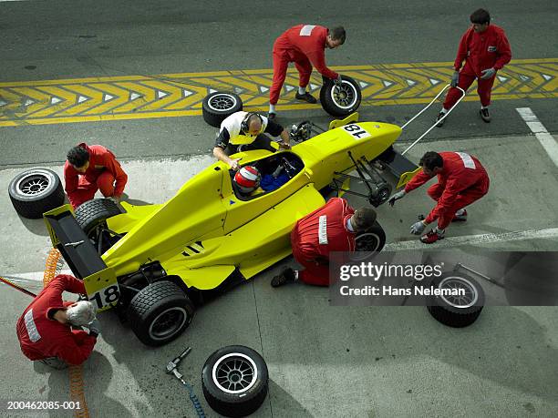 pit crew changing tires on open-wheel single-seater racing car race car, elevated view - pit stop stock pictures, royalty-free photos & images