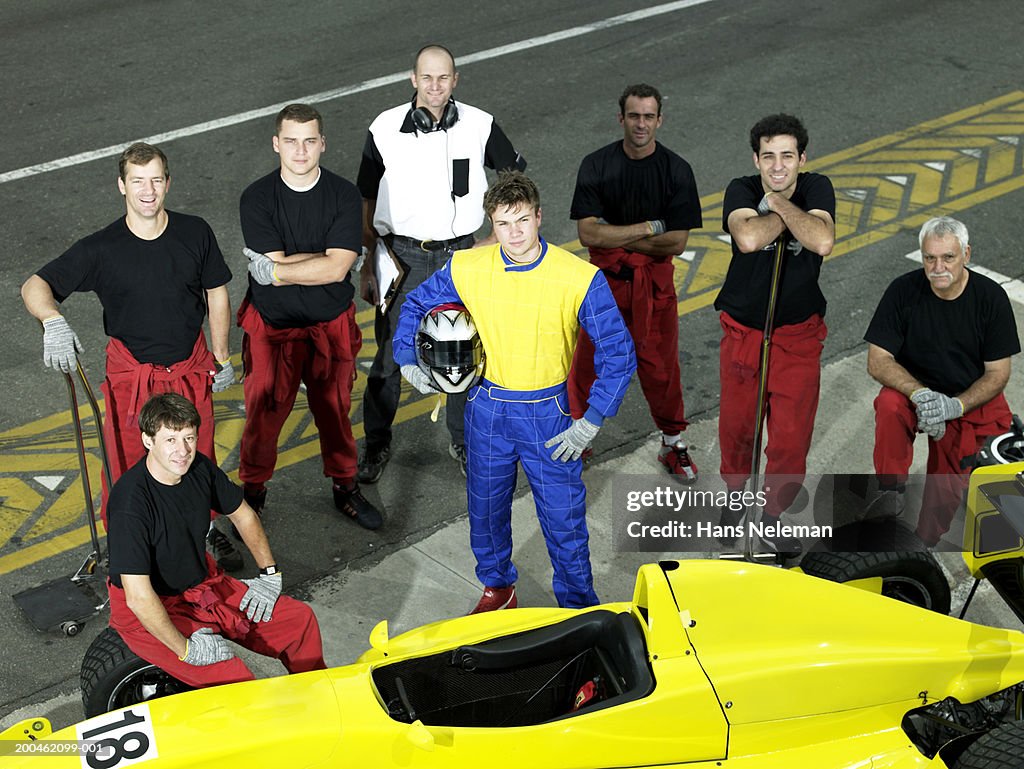 Driver and pit crew with open-wheel single-seater racing car race car, elevated view, portrait