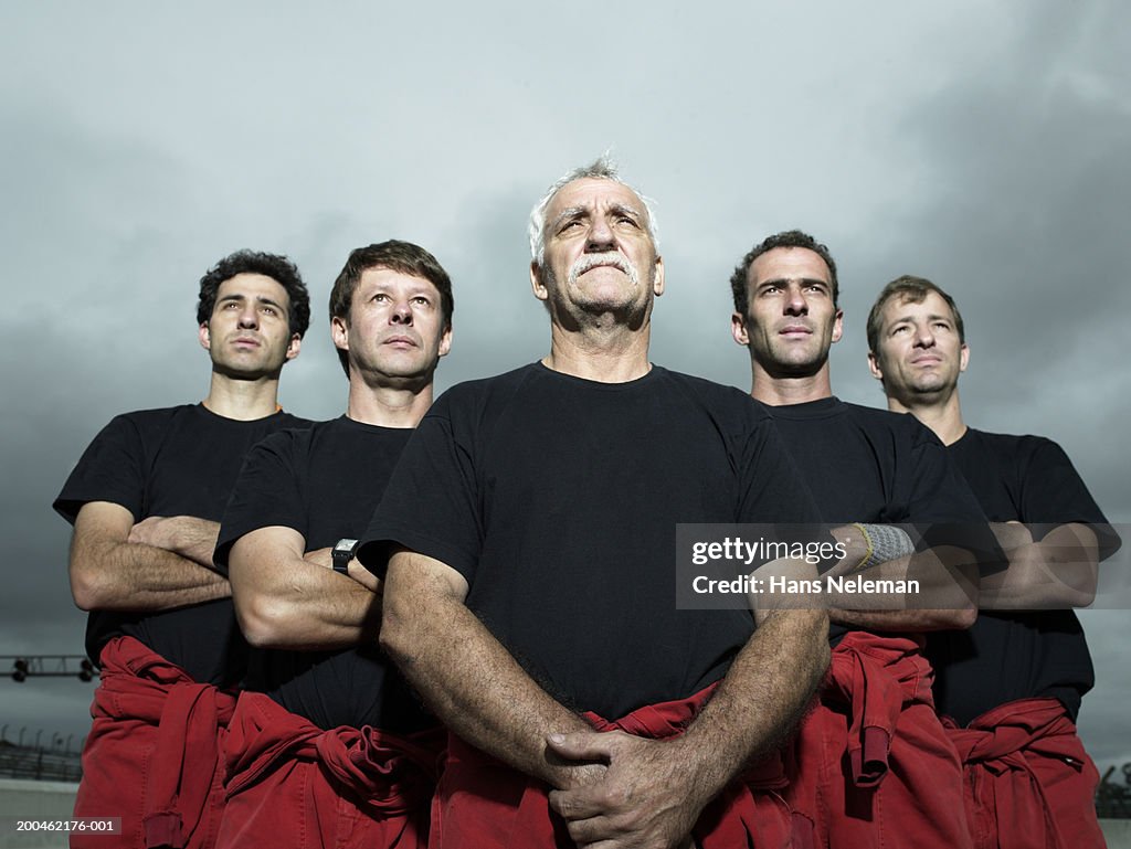 Racing team mechanics looking upwards