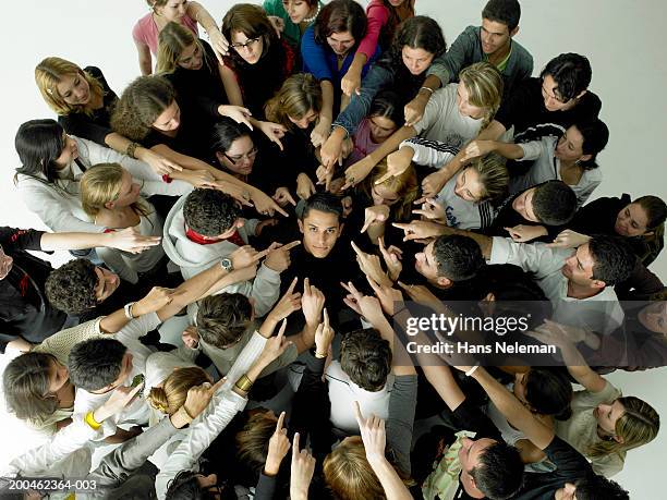 group pointing at man in center, elevated view - biasimo foto e immagini stock