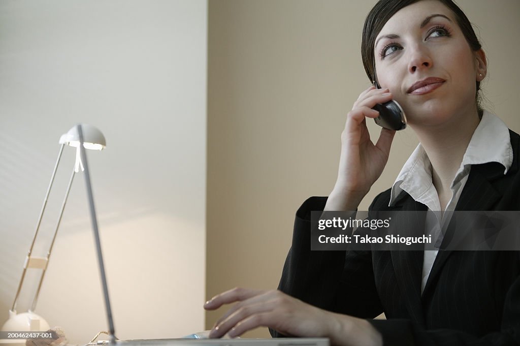 Young businesswoman talking on cell phone, smiling