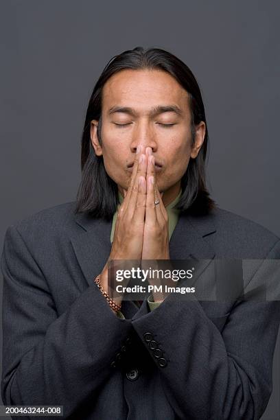 businessman pressing palms together in front of face - thankful man ストックフォトと画像