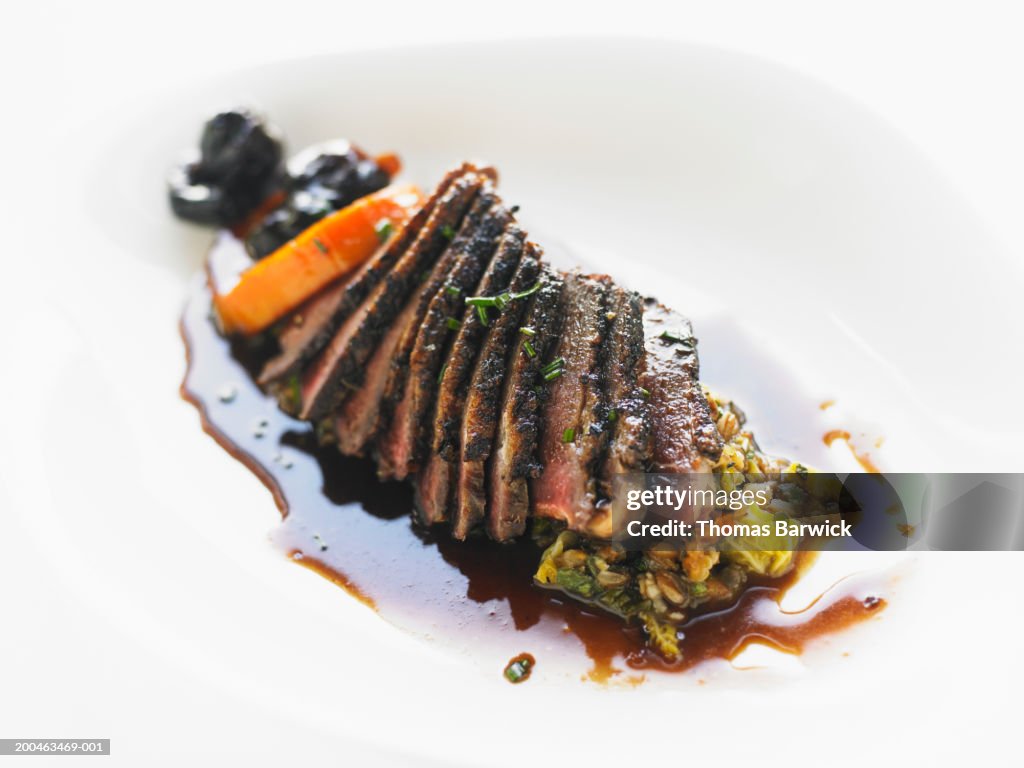 Beef tenderloin with napa cabbage saute, baby carrots and dried plums