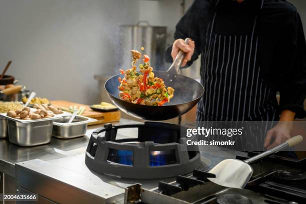 chef preparing food in restaurant kitchen - wok stockfoto's en -beelden