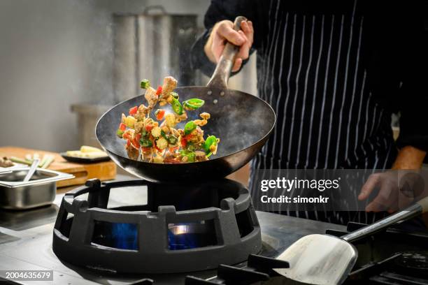 chef preparing food in restaurant kitchen - wok stockfoto's en -beelden