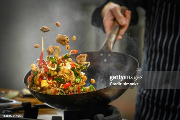 chef preparing food in restaurant kitchen - wok stock-fotos und bilder