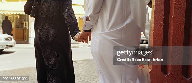 united arab emirates, dubai, couple holding hands, rear view - hijab woman from behind stock pictures, royalty-free photos & images