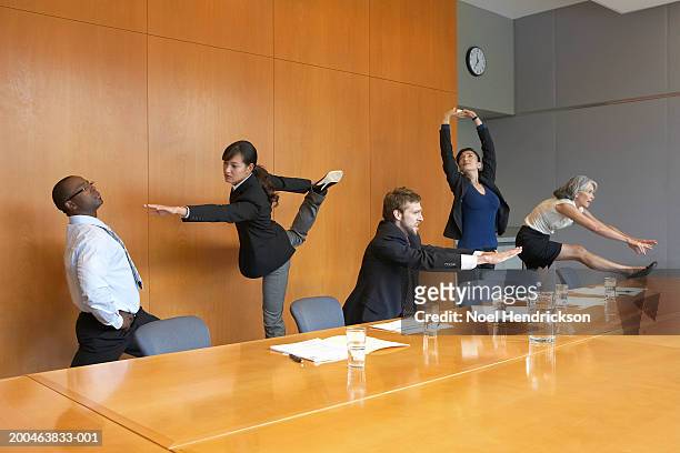 executives in conference room stretching - stretching fotografías e imágenes de stock