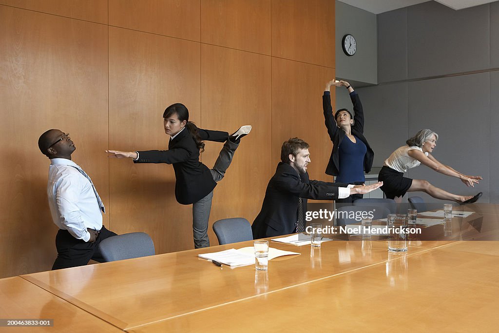 Executives in conference room stretching