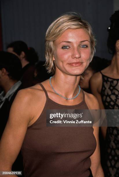 American actress Cameron Diaz, wearing a brown singlet, attends the 1997 MTV Movie Awards, held at Barker Hangar at Santa Monica Airport in Santa...