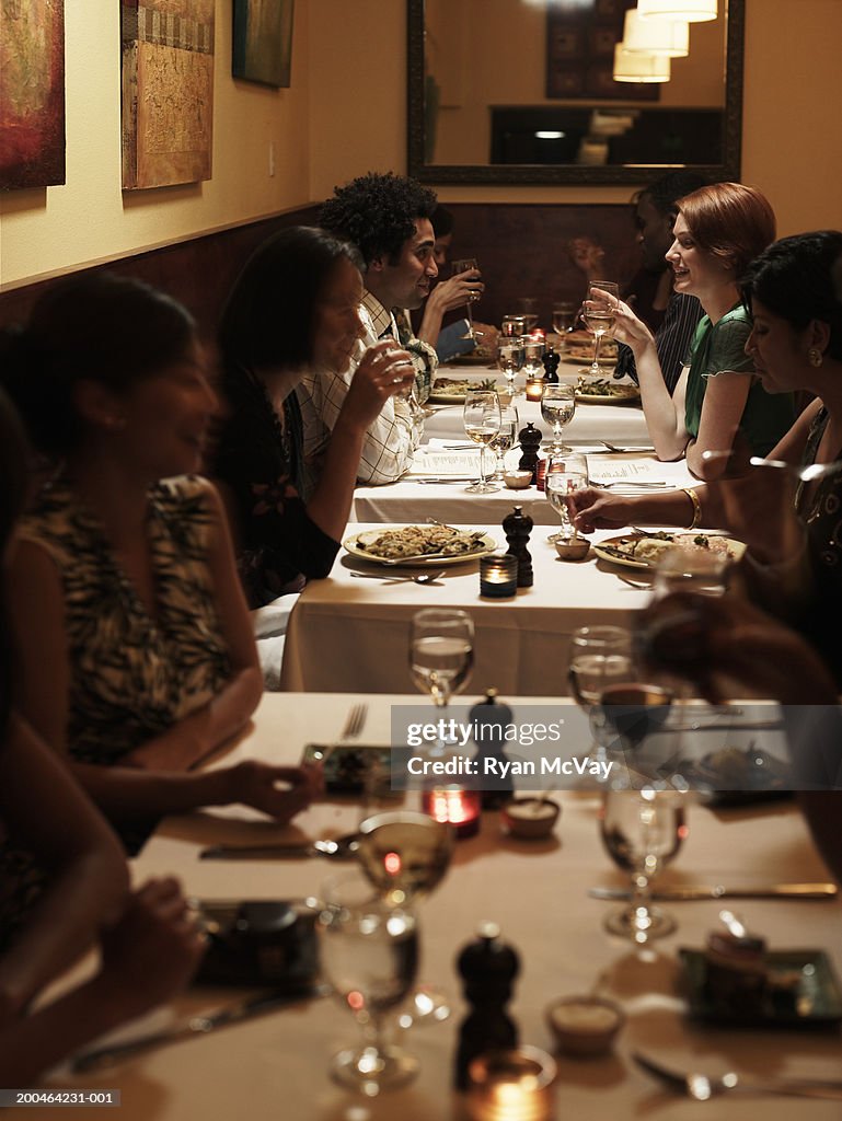 Adults in restaurant (focus on man and woman in background)