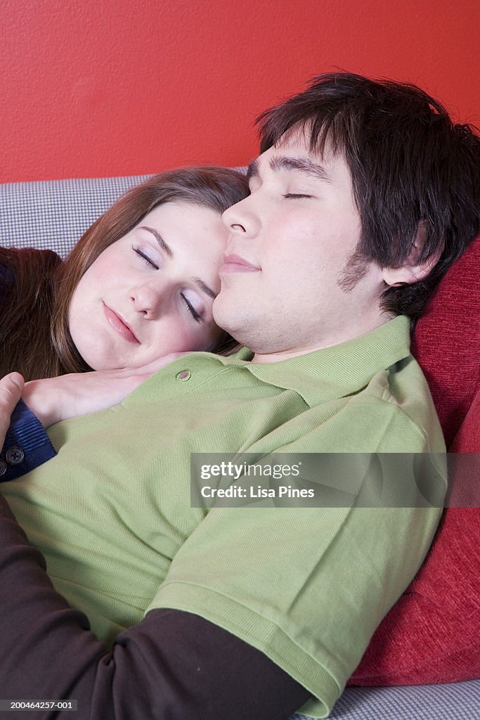 Young couple asleep on couch, side view, close-up