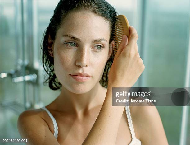 young woman combing hair, close-up - hair care stock pictures, royalty-free photos & images