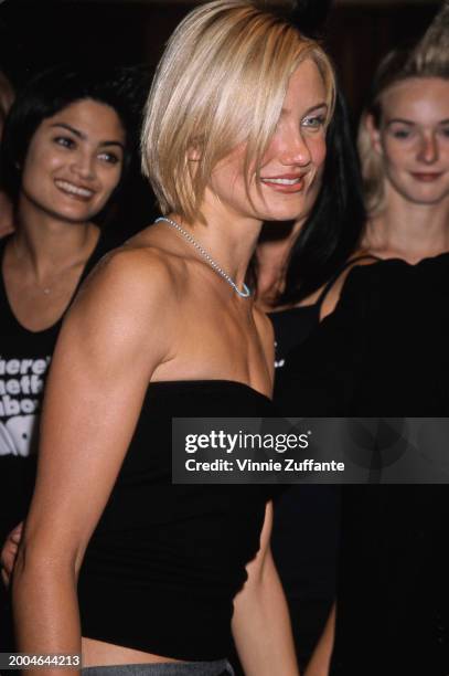 American actress Cameron Diaz, wearing a black tube top, attends the Westwood premiere of 'There's Something About Mary', held at the Mann Village...