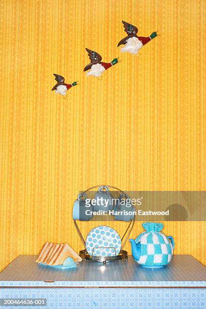 teapot and breakfast set on table, flying ducks on wall in background - kitsch stock pictures, royalty-free photos & images