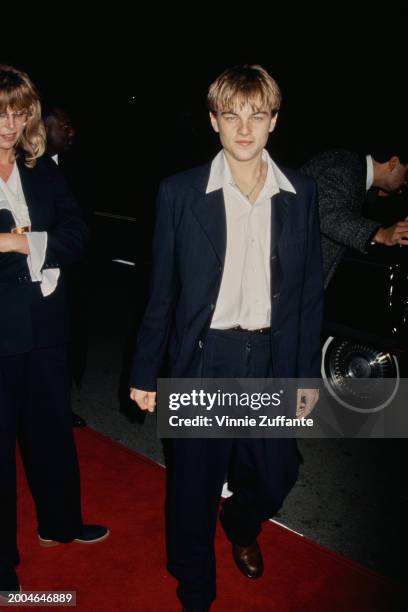 American actor Leonardo DiCaprio, wearing a white wide collar shirt beneath a black blazer, attends the Westwood premiere of 'The Basketball...