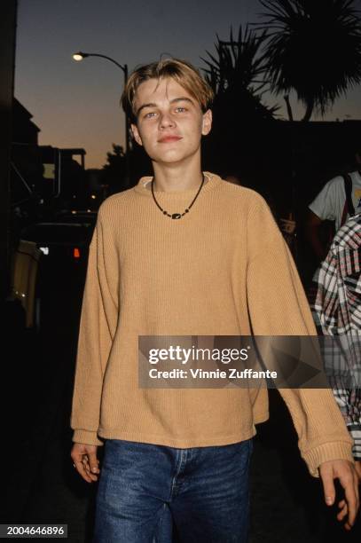 American actor Leonardo DiCaprio, wearing a yellow sweater and jeans, attends the 3rd Annual Celebrity Pool Tournament to Benefit AIDS Project Los...