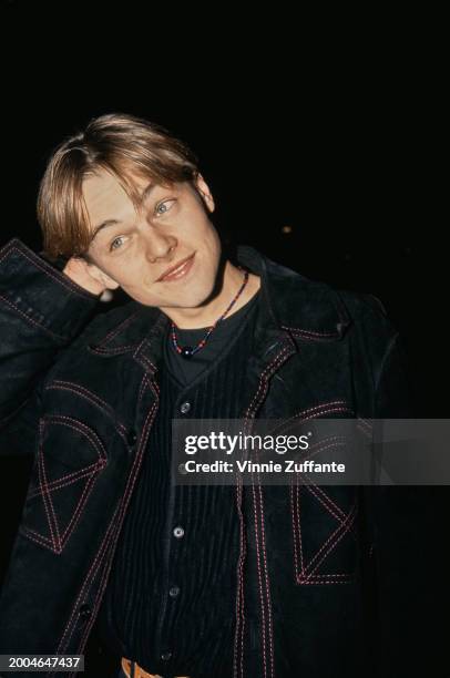 American actor Leonardo DiCaprio, wearing a black crew neck top beneath a black jacket with red stitching, attends the Hollywood premiere of 'What's...