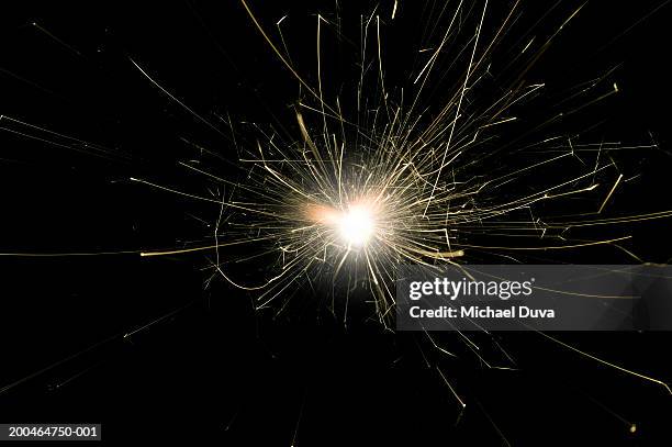 ignited sparkler against black background (blurred motion) - sparkler stock-fotos und bilder