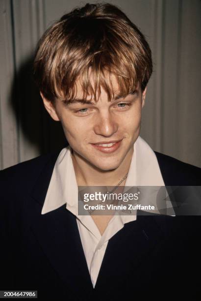 American actor Leonardo DiCaprio, wearing a white wide collar shirt beneath a black blazer, attends the Westwood premiere of 'The Basketball...
