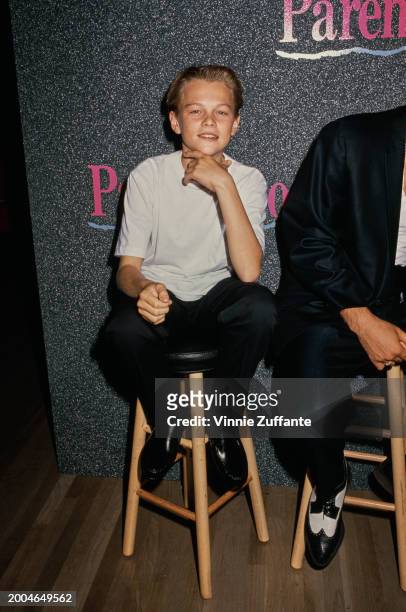 American actor Leonardo Di Caprio, sitting on a stool, attends an NBC 'Up Front' press conference, held in Los Angeles, California, 18th June 1990....