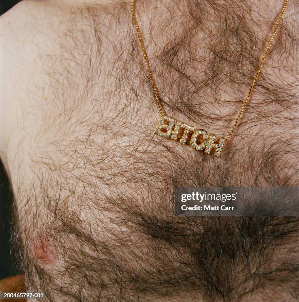 man wearing necklace spelling'bitch', mid section, close-up - female hairy chest stock-fotos und bilder