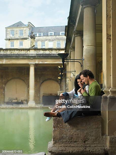 england, bath, young couple relaxing at side of roman spa - casa de banhos públicos imagens e fotografias de stock